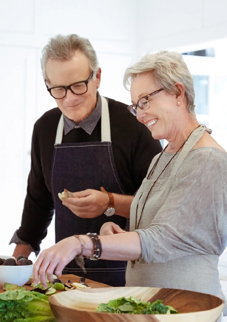 A happy couple cooks in their kitchen